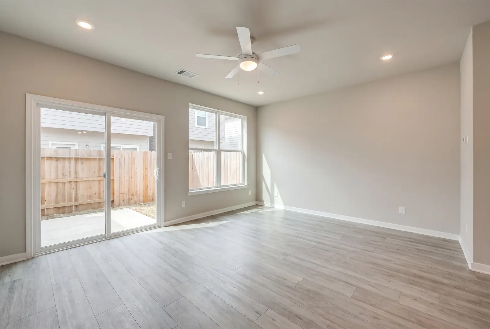 Empty open-plan living room with a sliding glass door
