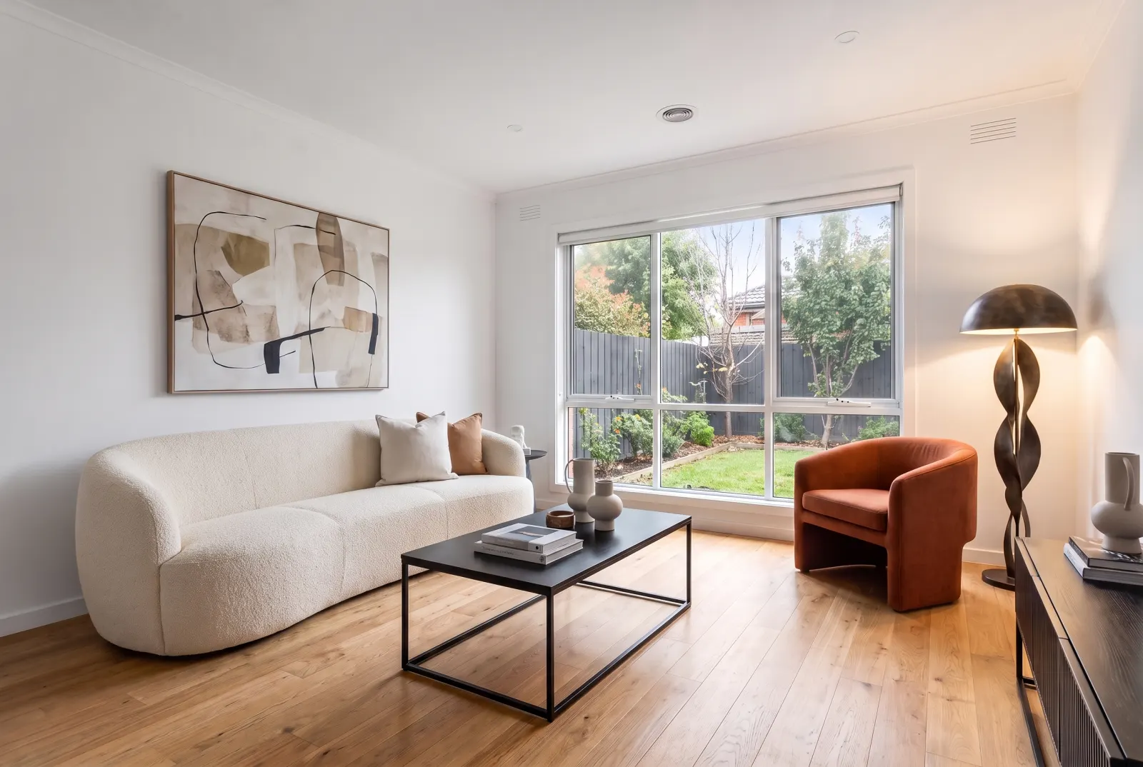 The same modern room with a curved bouclé sofa